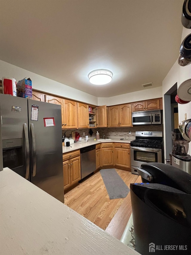 101 Michaels Ct, Woodbridge Proper, NJ 07095 - kitchen with stainless steel appliances, light wood-style flooring, light countertops, backsplash, and open shelves