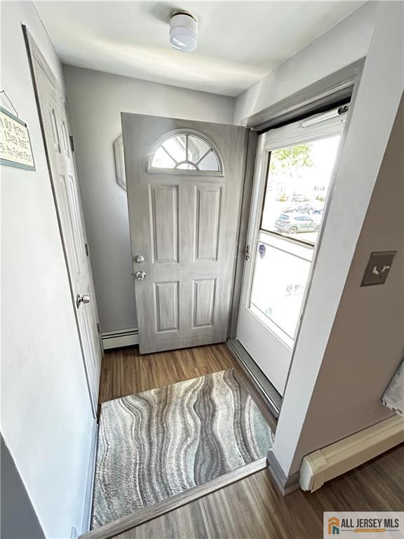 133 Pleasant Ave, Iselin, NJ 08830 - entryway with a baseboard heating unit, wood finished floors, and baseboards