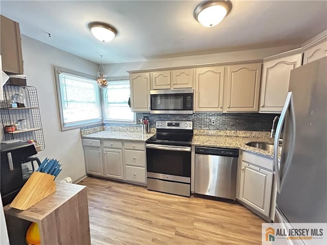 133 Pleasant Ave, Iselin, NJ 08830 - kitchen featuring appliances with stainless steel finishes, light wood-style flooring, tasteful backsplash, and light stone counters