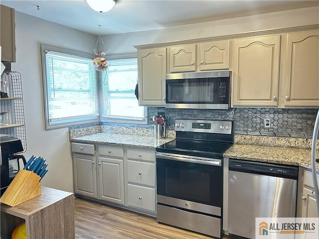 133 Pleasant Ave, Iselin, NJ 08830 - kitchen with stainless steel appliances, decorative backsplash, light wood-style flooring, and light stone countertops