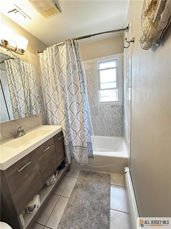 133 Pleasant Ave, Iselin, NJ 08830 - bathroom featuring vanity, tile patterned flooring, shower / bath combo with shower curtain, and a baseboard radiator