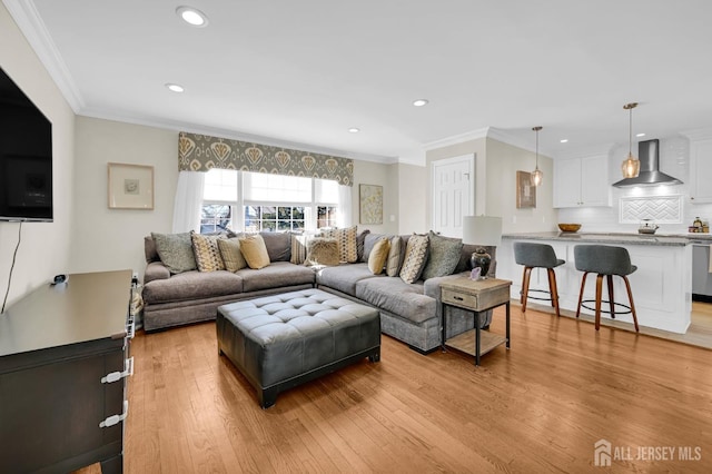 living area with light wood-style floors, recessed lighting, and crown molding