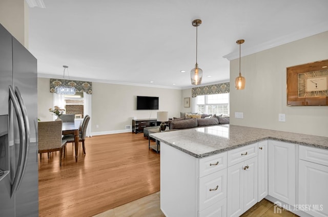 kitchen with a peninsula, white cabinetry, and stainless steel refrigerator with ice dispenser