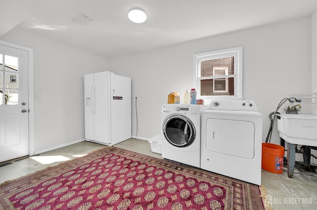 laundry area featuring baseboards and washer and clothes dryer