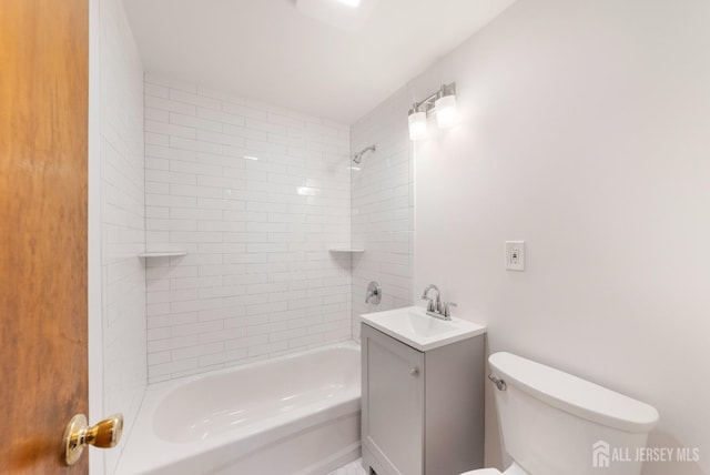 full bathroom featuring vanity, tiled shower / bath combo, and toilet