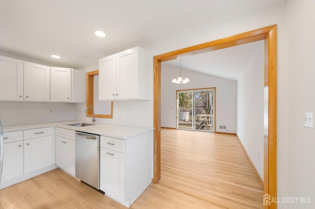 kitchen featuring lofted ceiling, white cabinetry, a notable chandelier, decorative light fixtures, and stainless steel dishwasher