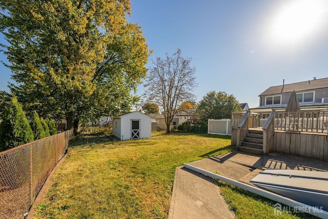 view of yard featuring a wooden deck and a shed