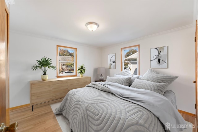 bedroom with crown molding and light hardwood / wood-style flooring