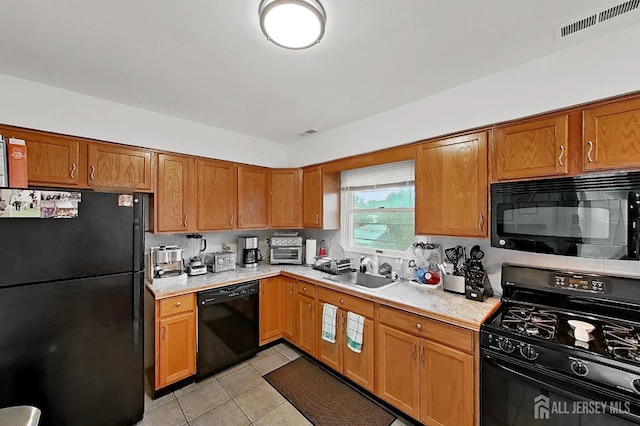 248 N 17th St N, Kenilworth, NJ 07033 - kitchen with black appliances, light countertops, light tile patterned floors, and brown cabinetry