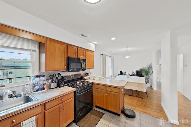 248 N 17th St N, Kenilworth, NJ 07033 - kitchen featuring black appliances, a peninsula, light countertops, light tile patterned flooring, and brown cabinetry