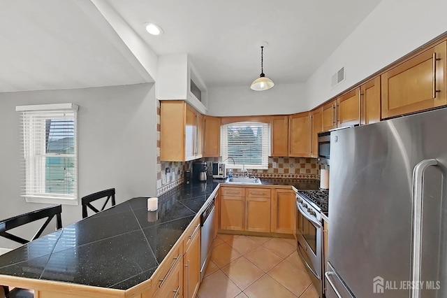 248 N 17th St N, Kenilworth, NJ 07033 - kitchen featuring appliances with stainless steel finishes, a peninsula, backsplash, light tile patterned flooring, and pendant lighting