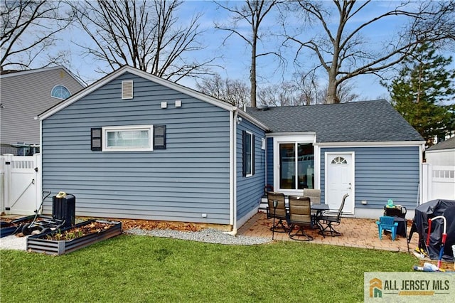 back of property with a gate, fence, a vegetable garden, a patio area, and a lawn