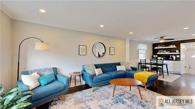 living room with recessed lighting, ornamental molding, and wood finished floors