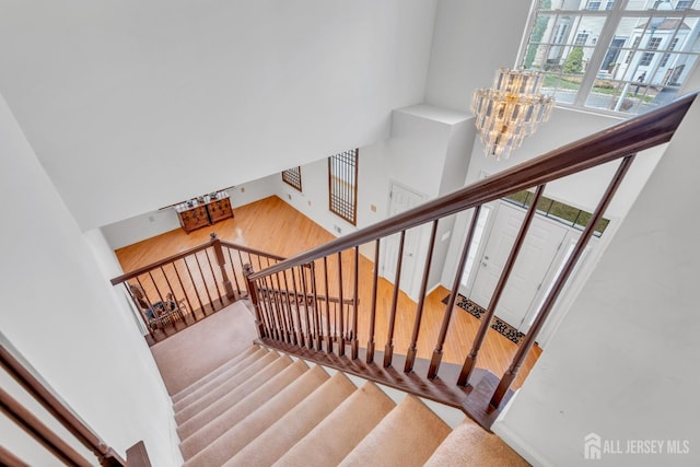 1 Kushnetki Rd, Parlin, NJ 08859 - stairway featuring a chandelier, a towering ceiling, and wood finished floors