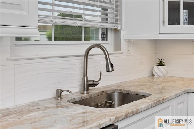 2 Belmar Rd Unit C, Monroe, NJ 08831 - kitchen view of backsplash, white cabinets, light stone counters, and glass insert cabinets