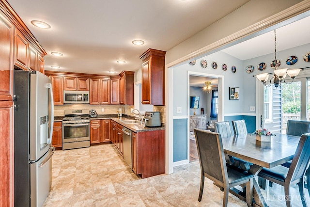 108 Morris Ave, Edison, NJ 08837 - kitchen featuring appliances with stainless steel finishes, brown cabinets, a chandelier, and tasteful backsplash