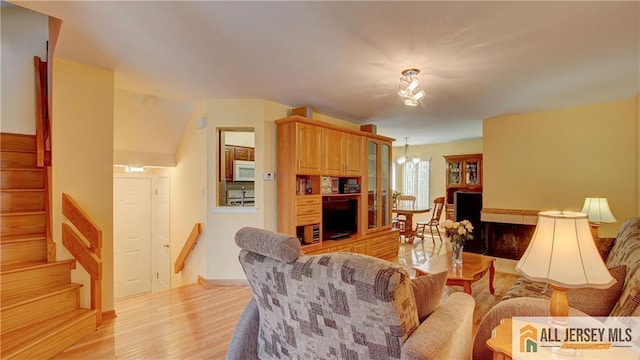 1141 Schmidt Ln, North Brunswick, NJ 08902 - living area featuring stairway, light wood-type flooring, and a chandelier