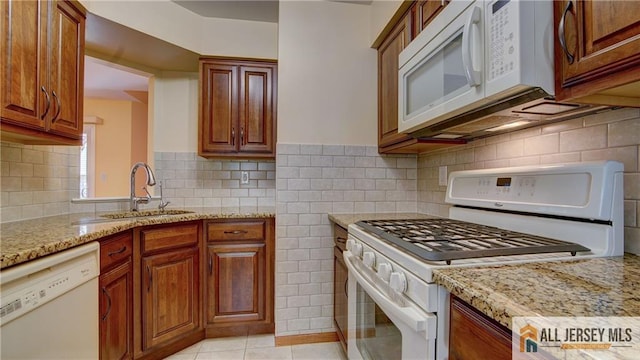 1141 Schmidt Ln, North Brunswick, NJ 08902 - kitchen featuring white appliances, a sink, light stone counters, brown cabinets, and light tile patterned floors