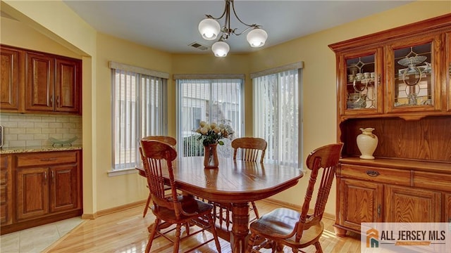 1141 Schmidt Ln, North Brunswick, NJ 08902 - dining space with healthy amount of natural light, a chandelier, baseboards, and light wood-style flooring