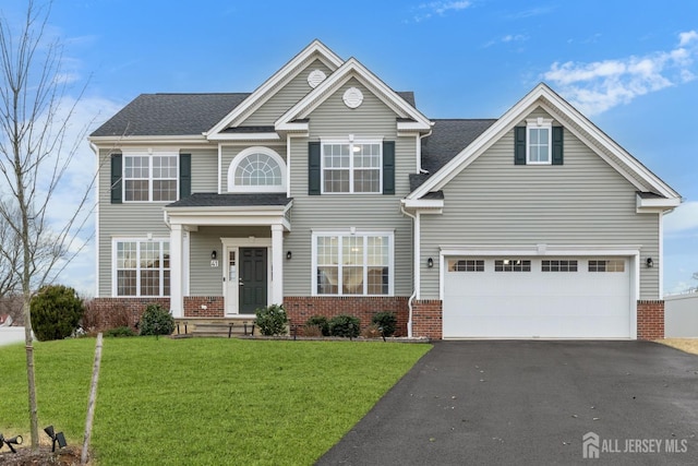 view of front of property featuring aphalt driveway, a garage, brick siding, and a front lawn