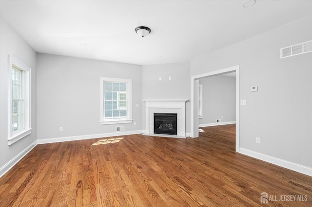 440 Ellisdale Rd, Chesterfield, NJ 08515 - unfurnished living room featuring visible vents, a fireplace with flush hearth, baseboards, and wood finished floors