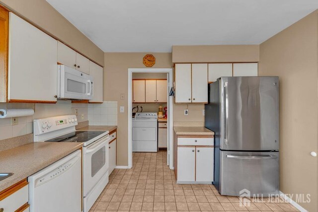 kitchen with light countertops, decorative backsplash, washer / clothes dryer, and white appliances