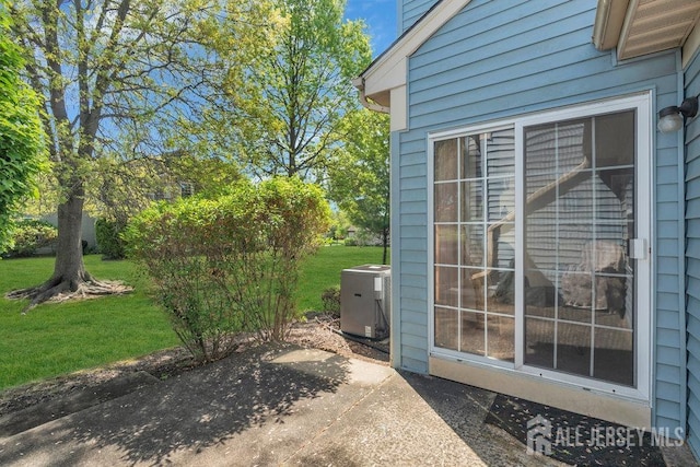 exterior space featuring a lawn, a patio, and central AC