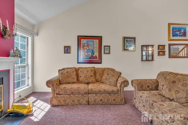 carpeted living area featuring baseboards, a glass covered fireplace, and lofted ceiling