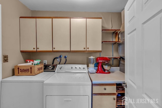washroom featuring cabinet space and washer and clothes dryer