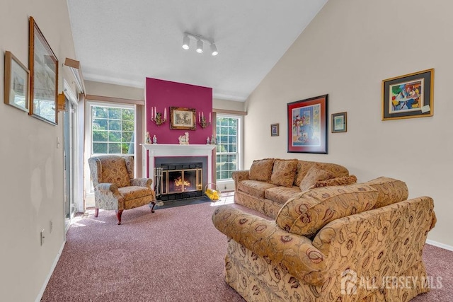 carpeted living room with baseboards, a fireplace with flush hearth, and lofted ceiling