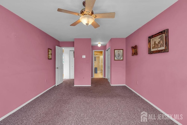 empty room with baseboards, a ceiling fan, and carpet