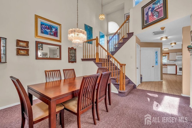 dining room featuring visible vents, carpet flooring, a chandelier, and stairway
