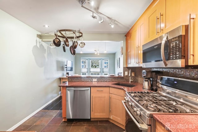 kitchen featuring sink, light brown cabinets, kitchen peninsula, backsplash, and appliances with stainless steel finishes