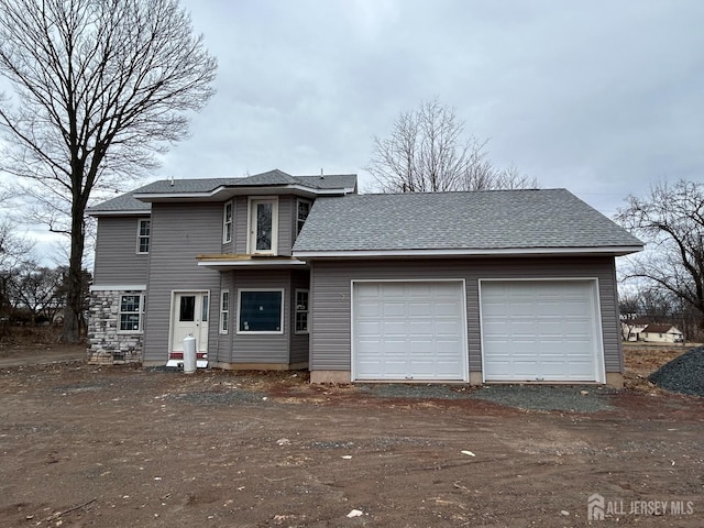 view of front of house featuring driveway, a garage, and roof with shingles