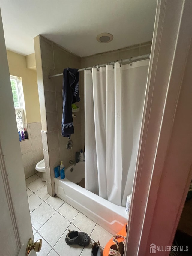 142 Joyce Kilmer Ave, New Brunswick, NJ 08901 - full bath with tile patterned floors, tile walls, shower / bath combo with shower curtain, toilet, and a wainscoted wall