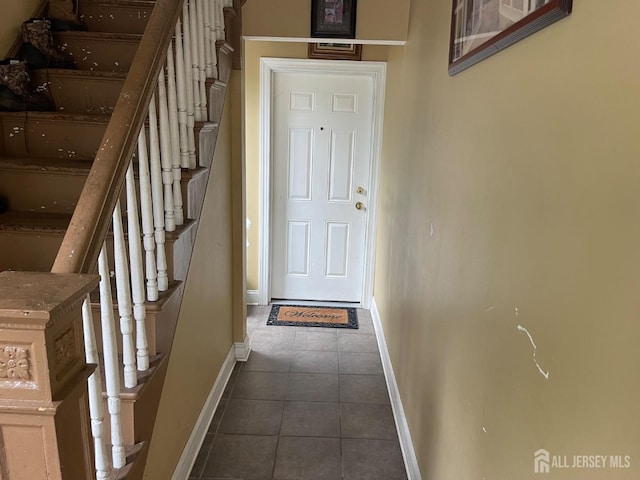 142 Joyce Kilmer Ave, New Brunswick, NJ 08901 - doorway featuring baseboards, dark tile patterned floors, and stairway