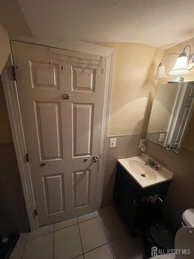 142 Joyce Kilmer Ave, New Brunswick, NJ 08901 - bathroom with tile patterned flooring, toilet, vanity, tile walls, and wainscoting