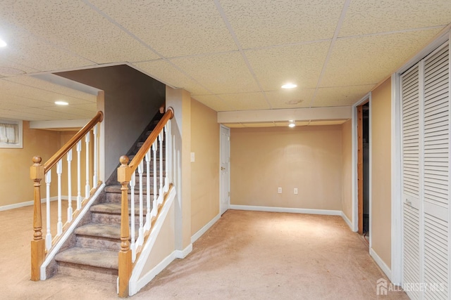 basement featuring carpet flooring and a drop ceiling