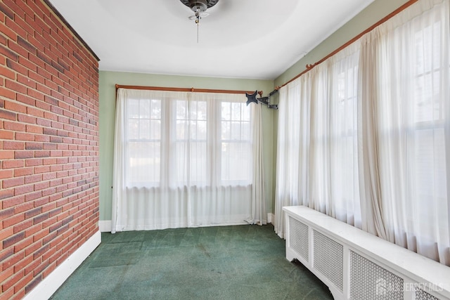 unfurnished sunroom featuring radiator heating unit