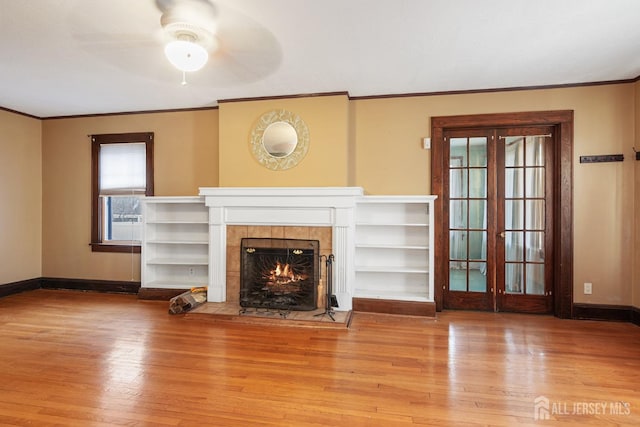 unfurnished living room with ceiling fan, a fireplace, light hardwood / wood-style floors, and ornamental molding