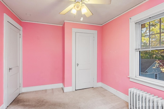 carpeted bedroom featuring radiator, ornamental molding, and ceiling fan