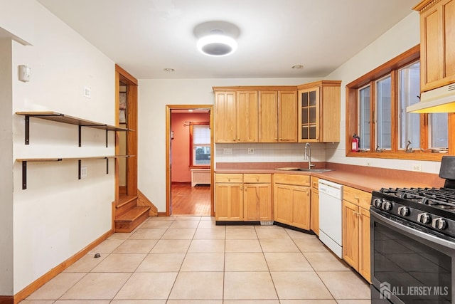 kitchen with dishwasher, light tile patterned floors, stainless steel gas stove, and sink