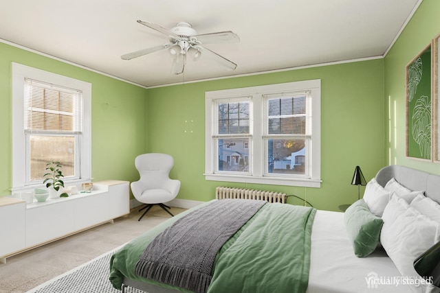 carpeted bedroom featuring ceiling fan, ornamental molding, radiator, and multiple windows