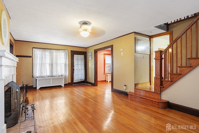 entrance foyer featuring light wood-type flooring, ornamental molding, and radiator