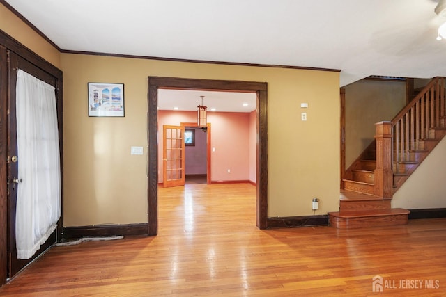 foyer entrance with light wood-type flooring and ornamental molding