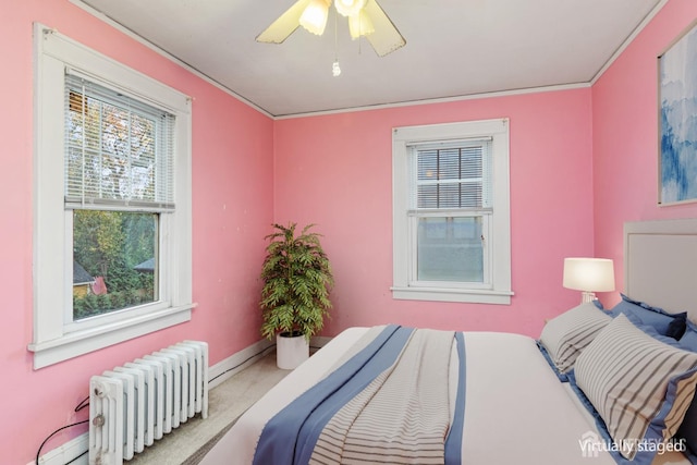 carpeted bedroom with radiator, ceiling fan, and crown molding