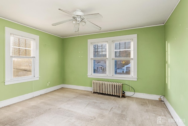 unfurnished room featuring ceiling fan, light colored carpet, ornamental molding, and radiator