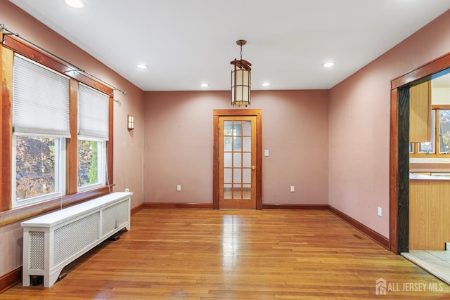 unfurnished room with light wood-type flooring and radiator