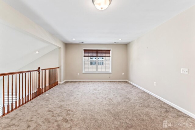 unfurnished room featuring vaulted ceiling and carpet