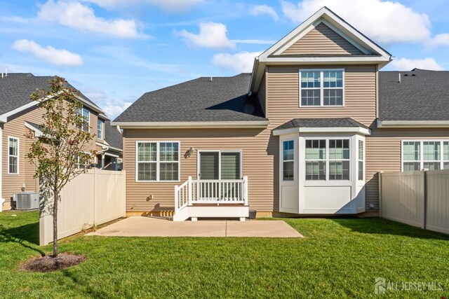 rear view of property with a patio, central AC unit, and a lawn